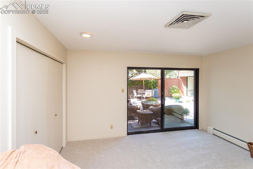 Image 22 of 35: Unfurnished bedroom featuring baseboard heating, access to outside, carpet,