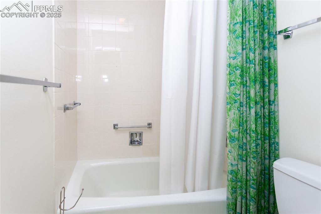 Image 23 of 35: Full bathroom featuring shower / bath combination with curtain and toilet