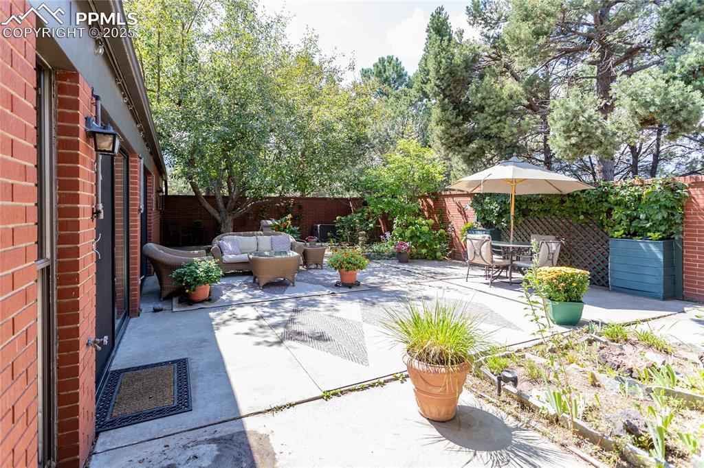 Image 26 of 35: Fenced backyard with a patio area and an outdoor hangout area