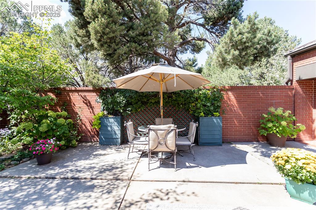 Image 28 of 35: Fenced backyard featuring outdoor dining space and a patio area