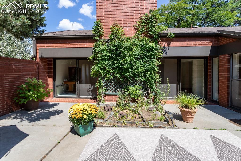 Image 29 of 35: Rear view of property featuring brick siding and a patio area