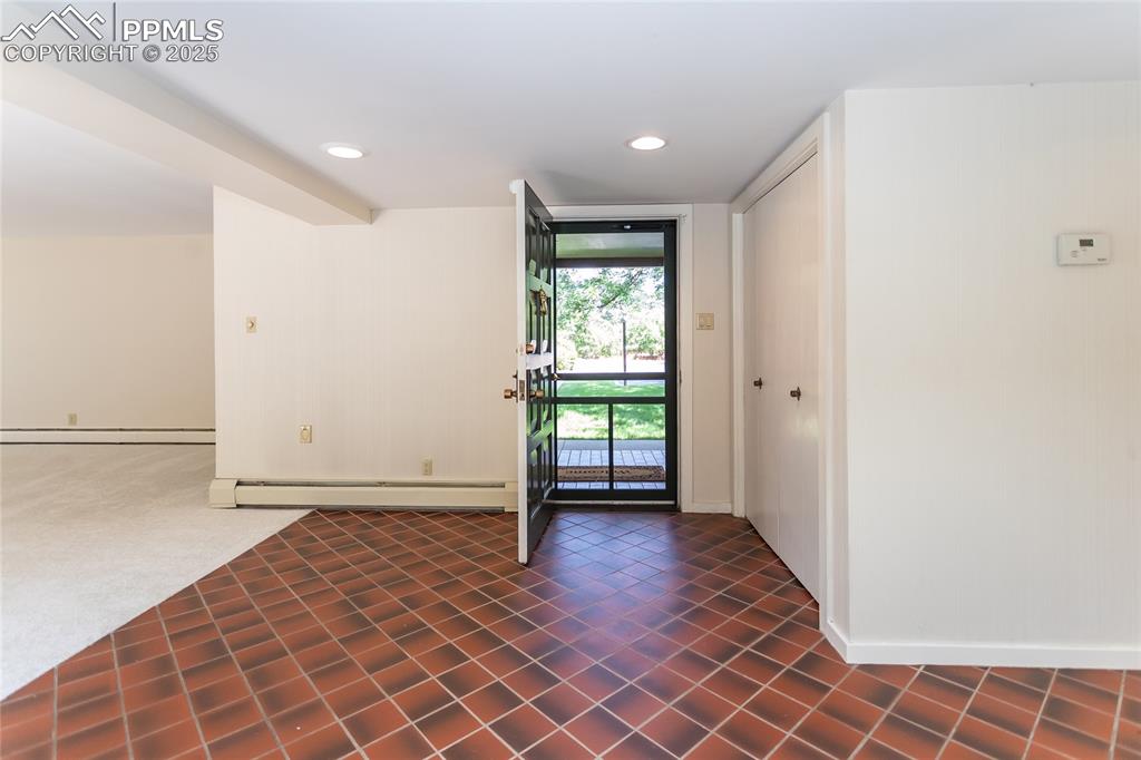 Image 3 of 35: Foyer with recessed lighting, a baseboard heating unit, and dark tile patte