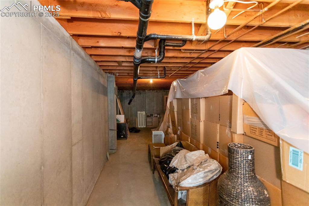 Image 33 of 35: Unfinished basement featuring radiator