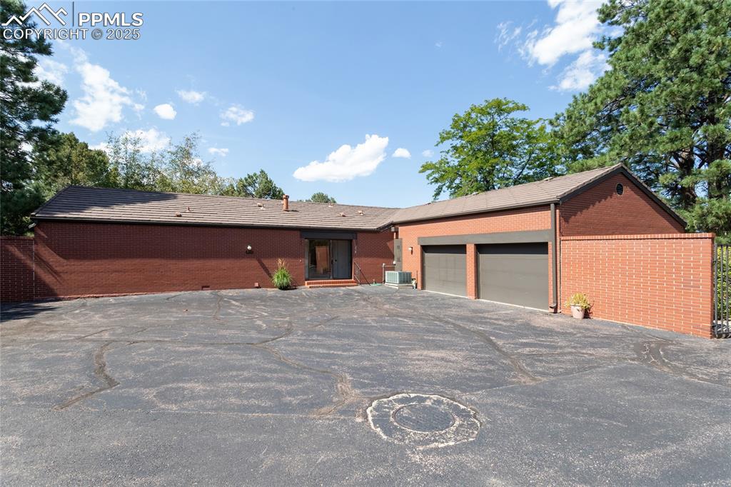 Image 35 of 35: Ranch-style home featuring driveway, brick siding, and a garage