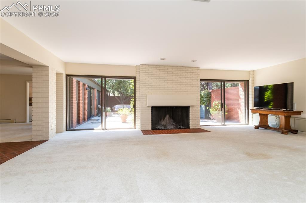 Image 5 of 35: Unfurnished living room with plenty of natural light, carpet, a fireplace, 