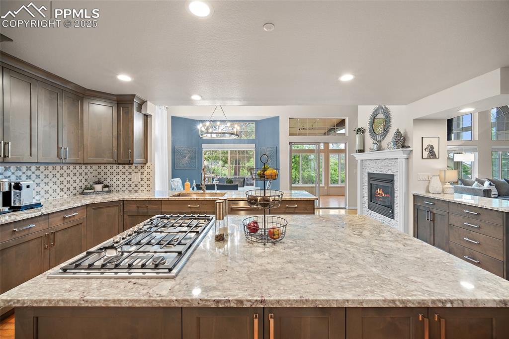 Image 14 of 50: Kitchen with stainless steel gas stovetop, a kitchen island, a sink, a glas