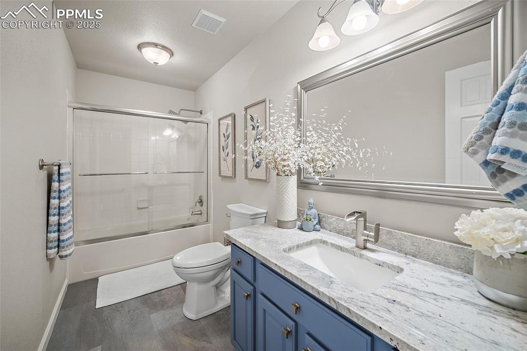 Image 31 of 50: Full bath with vanity, toilet, combined bath / shower with glass door