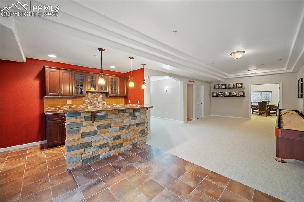Image 35 of 50: Basement living room with wet bar and walk out