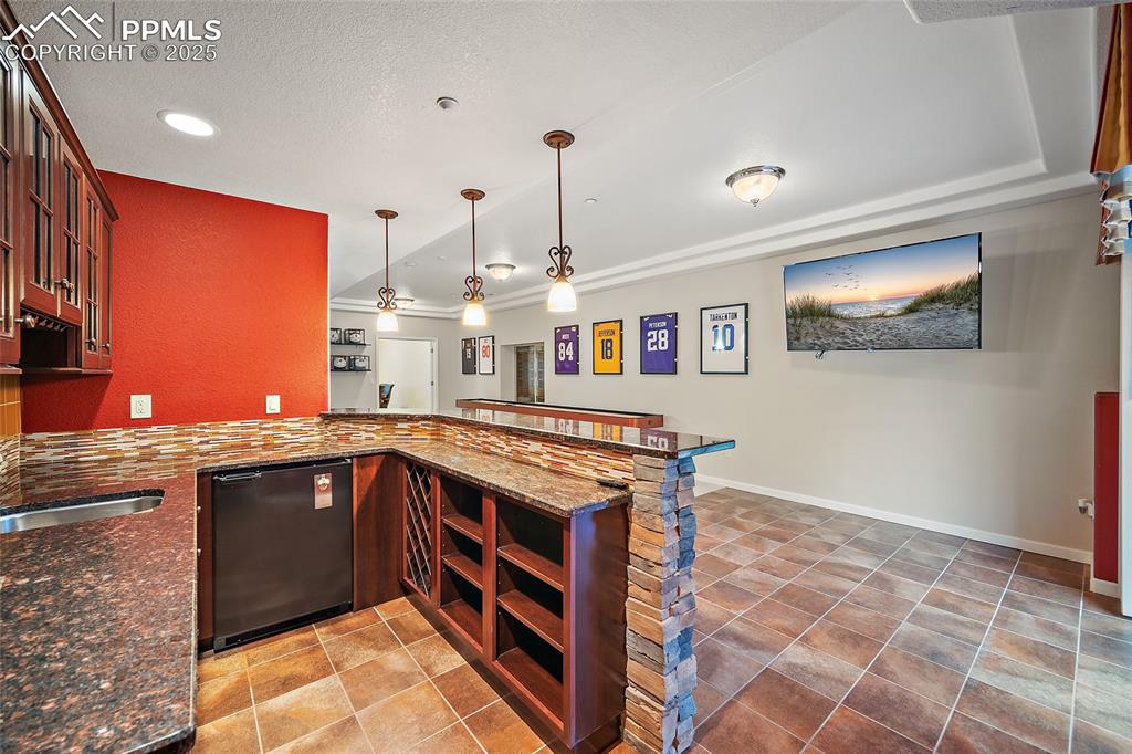 Image 36 of 50: Basement living room with wet bar and walk out