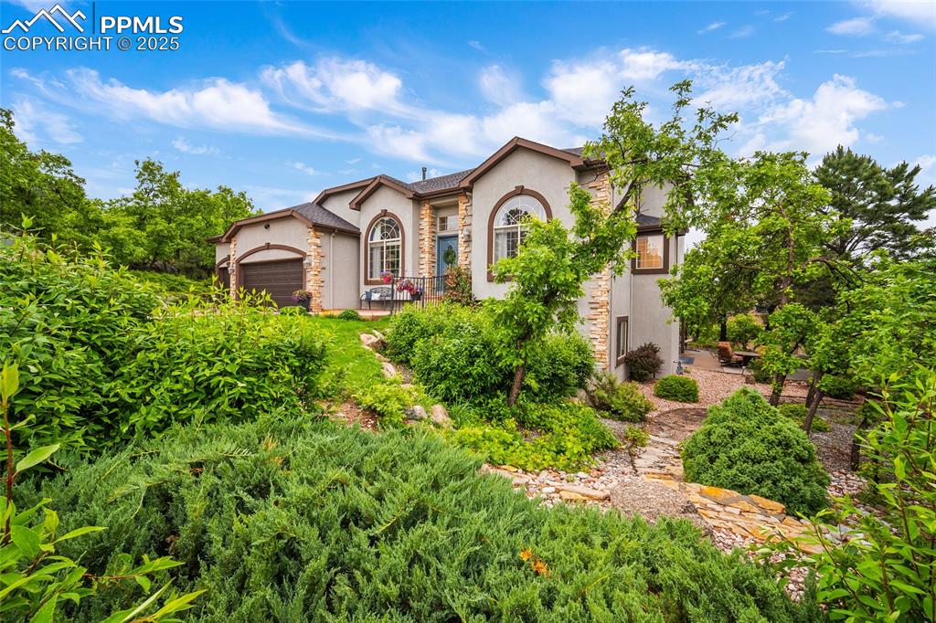 Image 48 of 50: Mediterranean / spanish house featuring stucco siding, stone siding, and an