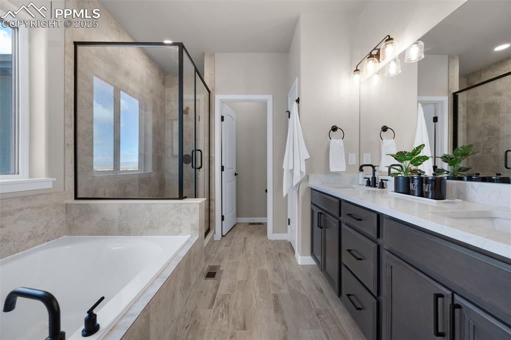 Image 10 of 36: Bathroom featuring a sink, double vanity, a shower stall