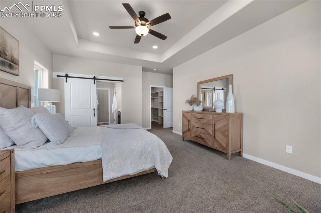 Image 9 of 36: Carpeted bedroom with baseboards, recessed lighting, a barn door, and a wal