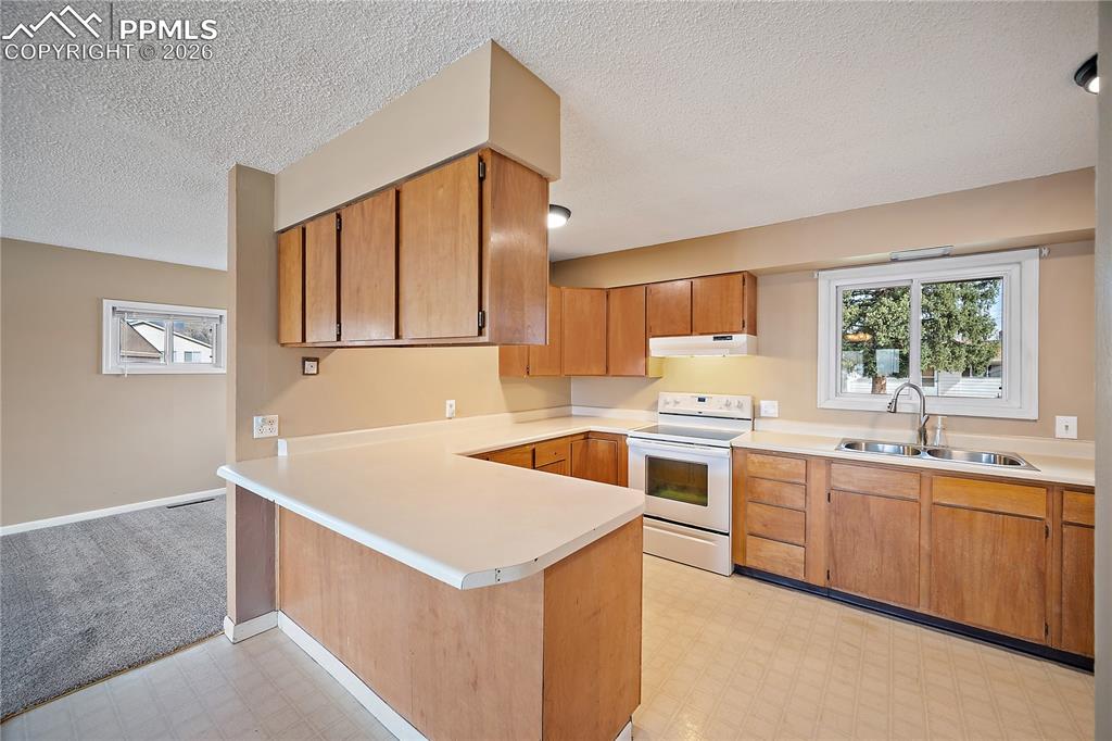 Image 10 of 38: Kitchen features breakfast bar, lots of cabinet and counter space.
