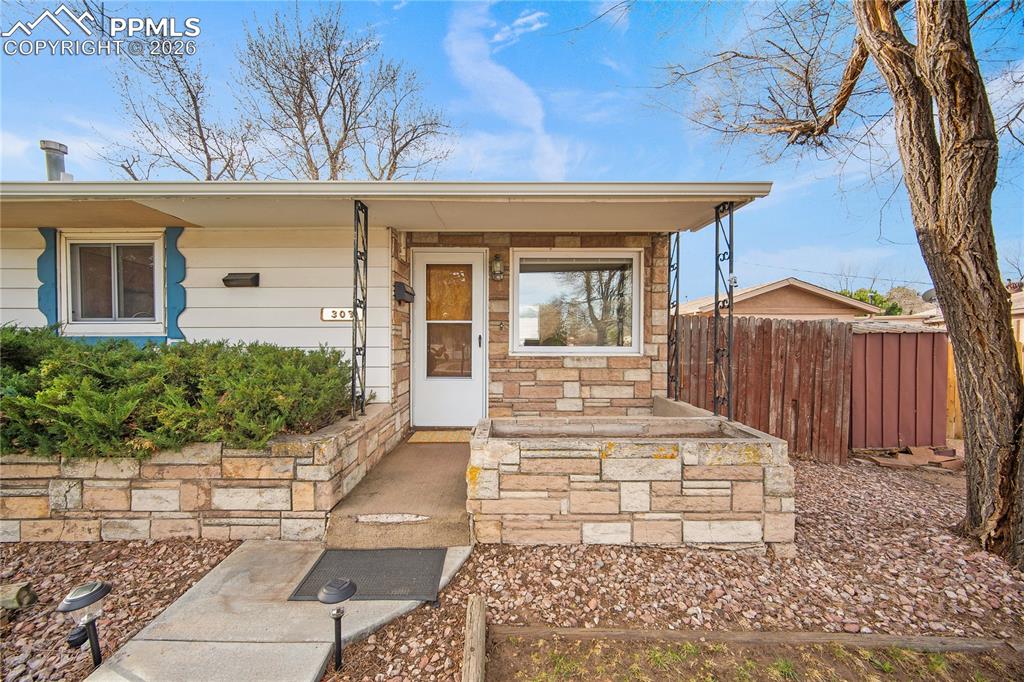 Image 2 of 38: Covered front porch with planter.