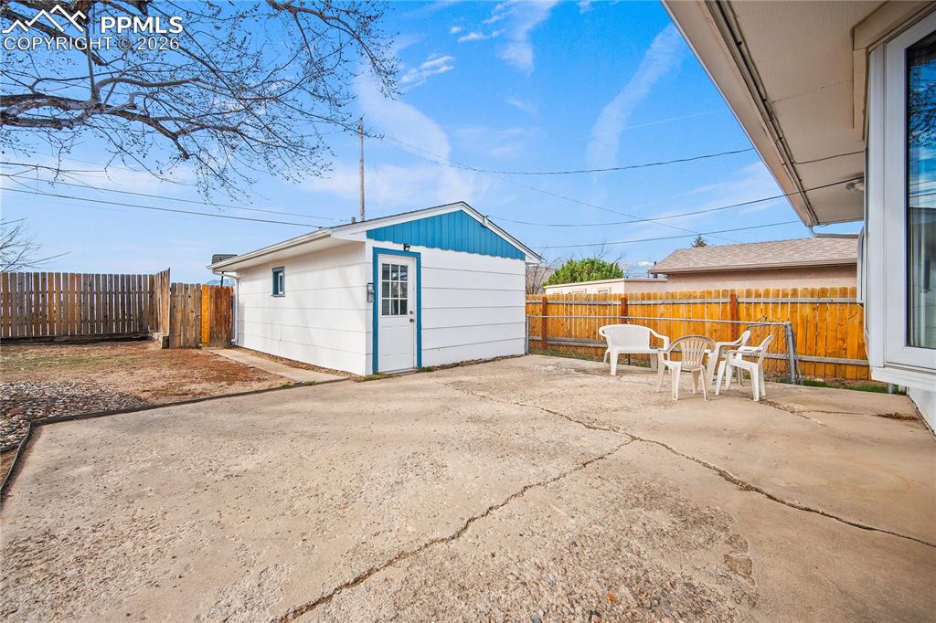 Image 26 of 38: Large concrete patio, fully fenced back yard and detached 1 car garage.