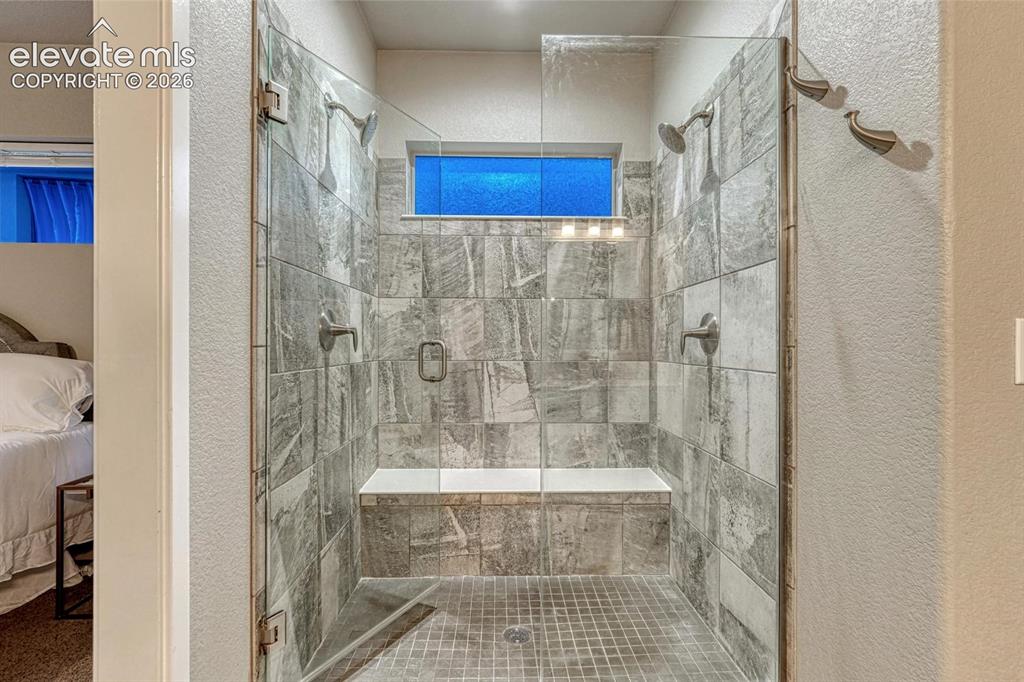 Image 11 of 43: Primary double shower with bench