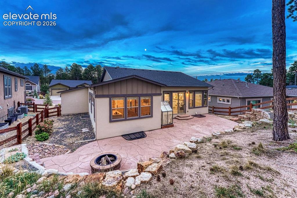 Image 33 of 43: Huge custom stamped concrete patio with permanent firepit and tiered, xeris