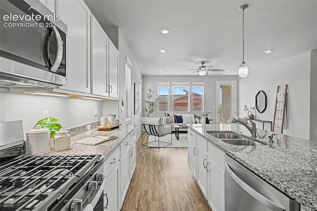 Image 11 of 45: Kitchen featuring granite countertops, white cabinetry, stainless steel app