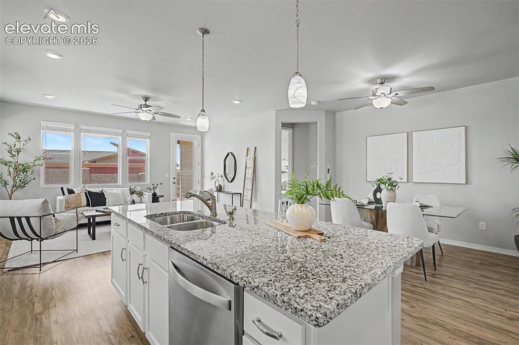 Image 12 of 45: Spacious open-concept living area featuring a kitchen island with granite c