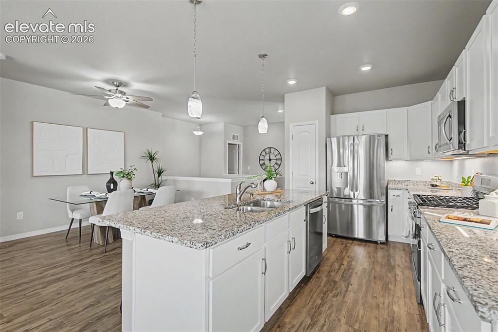 Image 13 of 45: Kitchen featuring white cabinetry, stainless steel appliances, and granite