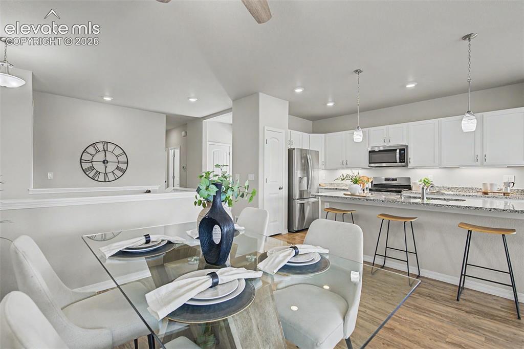 Image 16 of 45: Modern kitchen featuring white cabinetry, stainless steel appliances, and a