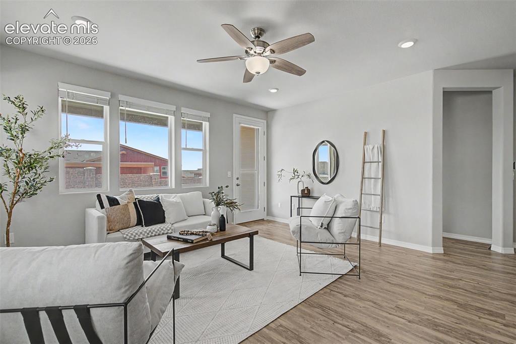 Image 19 of 45: Open-concept living area featuring wood-finish flooring, a contemporary cei