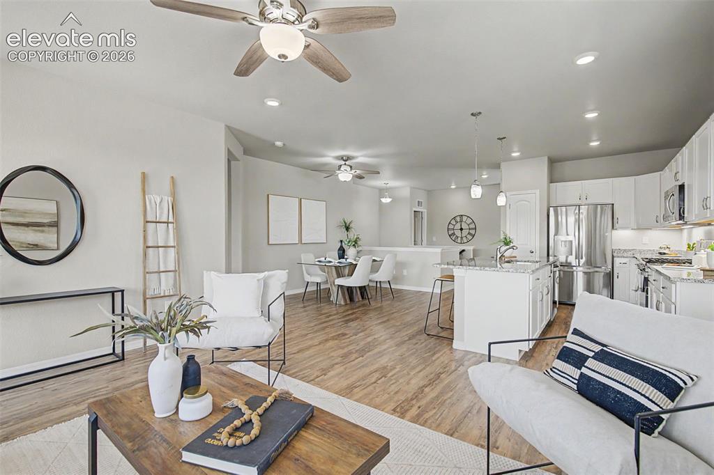 Image 20 of 45: Open-concept living space featuring wood-finish flooring, recessed lighting