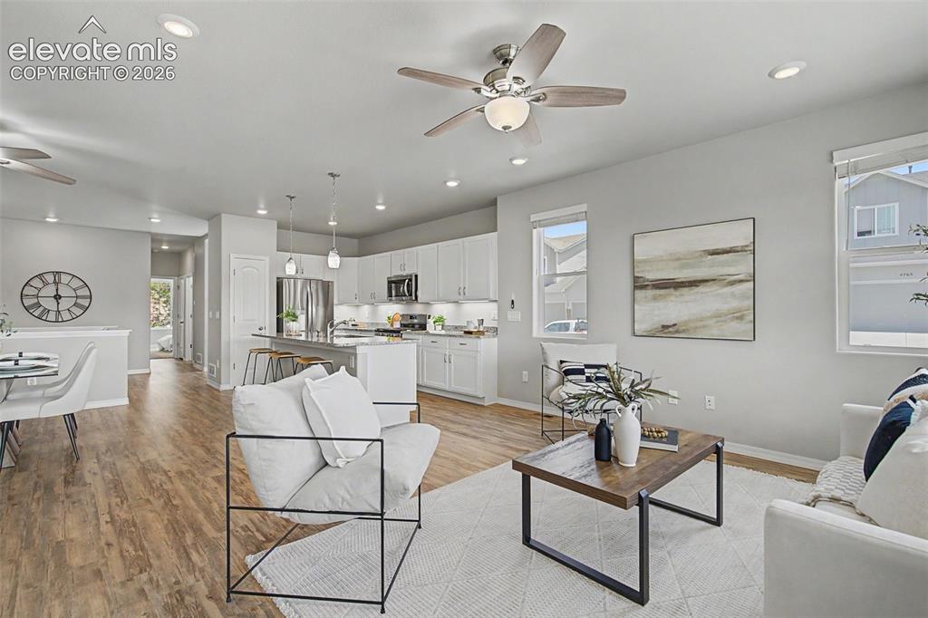 Image 21 of 45: Open-concept living space featuring wood-finish flooring, recessed lighting