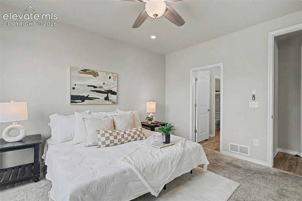 Image 23 of 45: Neutral-toned bedroom featuring a ceiling fan with integrated lighting, rec