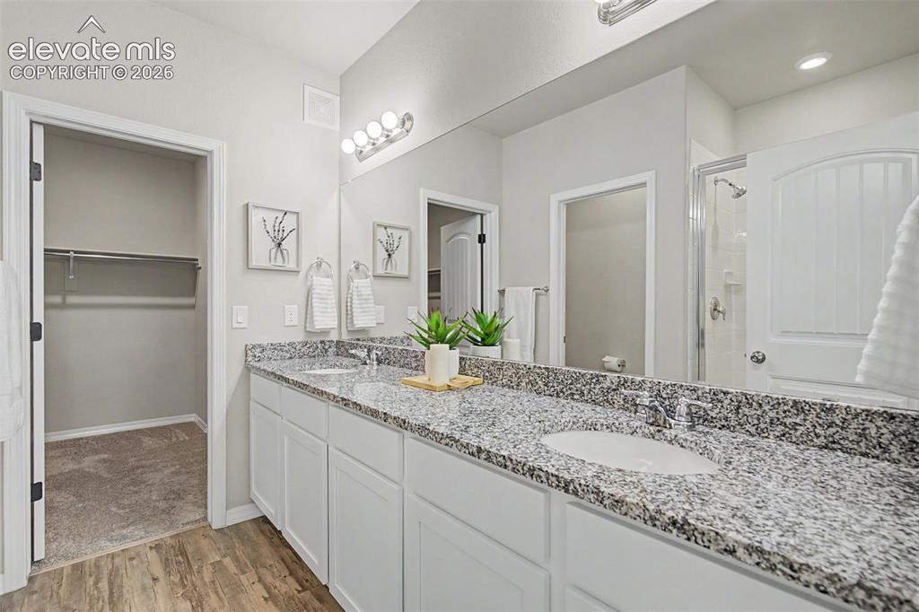 Image 24 of 45: Dual vanity with speckled granite-finish countertop and undermount sinks, w