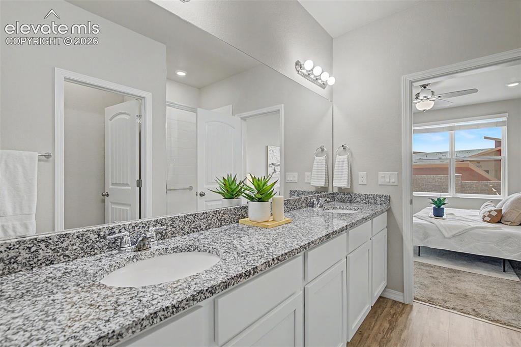 Image 25 of 45: Bathroom featuring a double vanity with stone countertop, undermount sinks,
