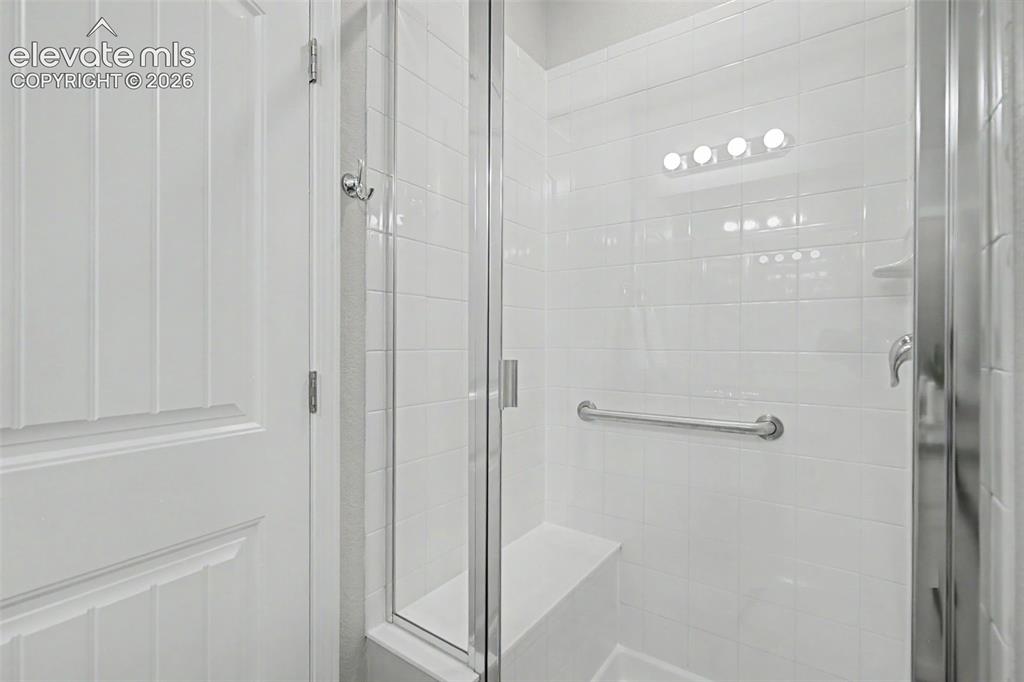 Image 26 of 45: Walk-in shower featuring a clear glass enclosure, white subway tile surroun