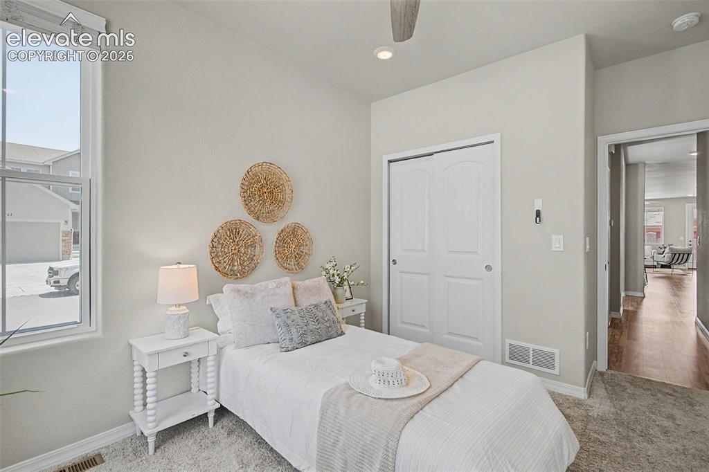 Image 29 of 45: Carpeted room with a vaulted ceiling, a large window, and a ceiling fan