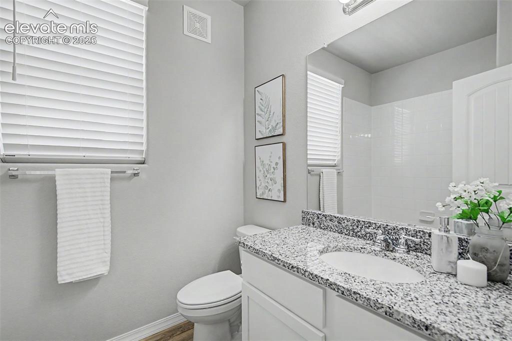 Image 31 of 45: Bathroom featuring a vanity with a granite countertop, undermount sink, and