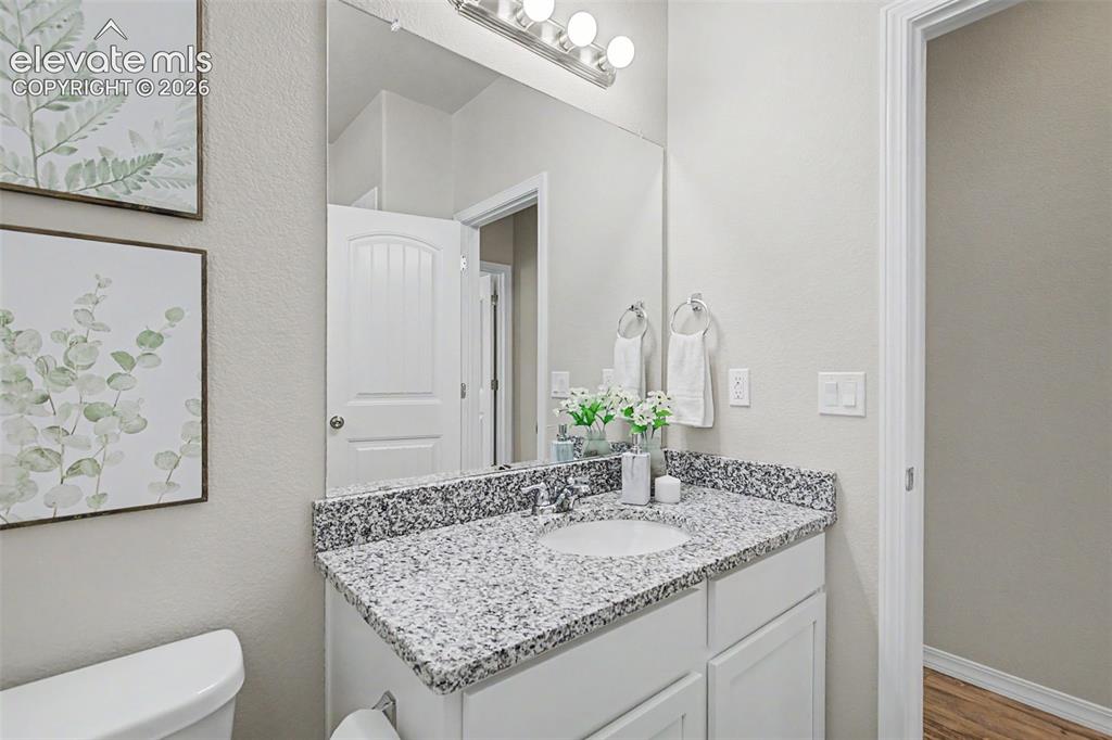 Image 32 of 45: Bathroom vanity featuring a speckled countertop, integrated sink, and white