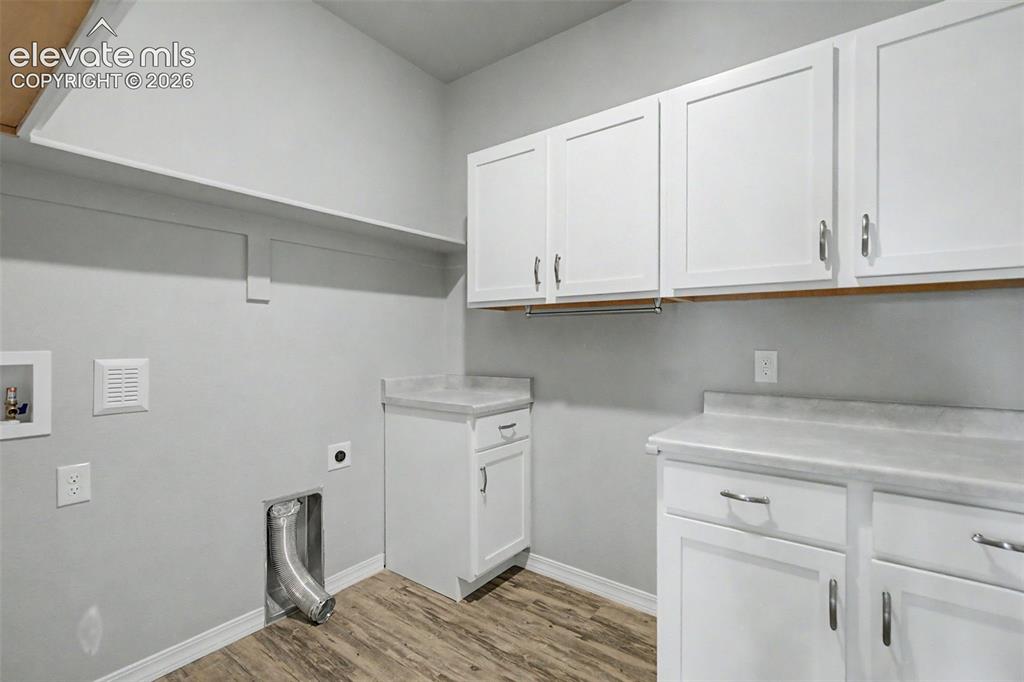 Image 33 of 45: Dedicated utility room featuring wood-finish flooring