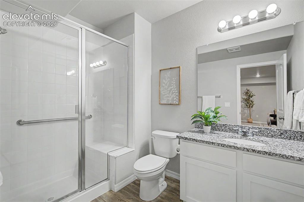Image 38 of 45: Bathroom featuring a glass-enclosed shower with white subway tile, a built-