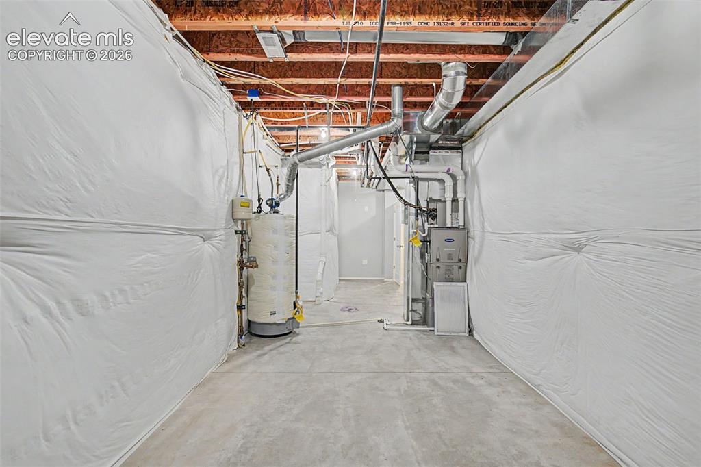 Image 39 of 45: Unfinished basement featuring exposed wood joists, concrete flooring, and i