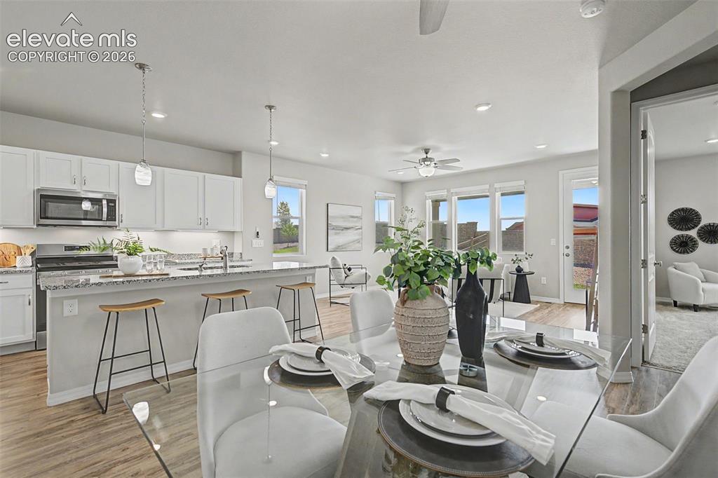 Image 5 of 45: Open-concept living area featuring wood-finish flooring, a kitchen island w