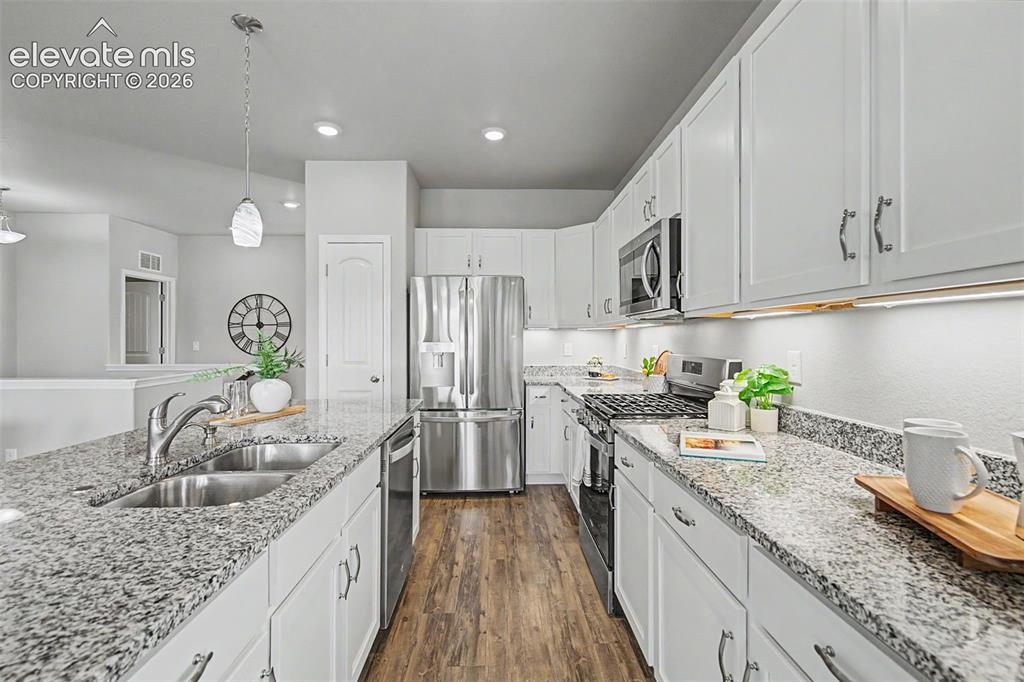 Image 9 of 45: Kitchen featuring white cabinetry, granite countertops, stainless steel app