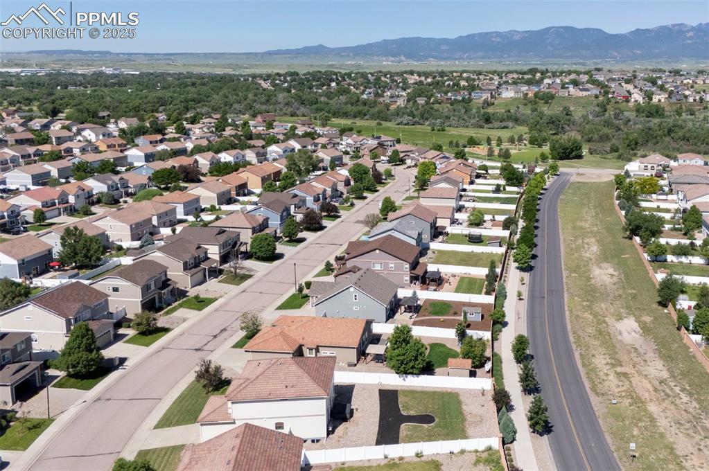 Image 16 of 50: Aerial perspective of suburban area with a mountainous background