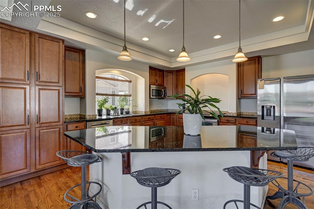 Image 27 of 50: Kitchen featuring appliances with stainless steel finishes, a tray ceiling,