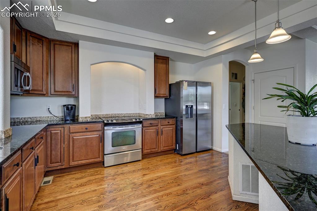 Image 29 of 50: Kitchen featuring appliances with stainless steel finishes, arched walkways