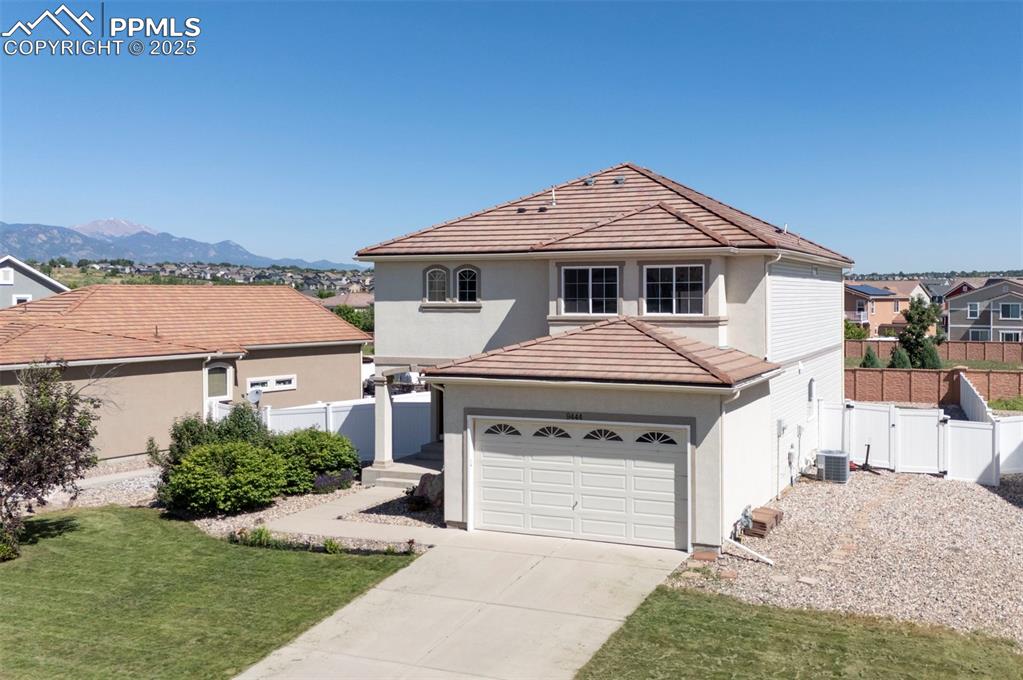 Image 3 of 50: View of front of house featuring a tiled roof, concrete driveway, stucco si