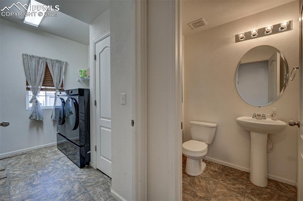 Image 31 of 50: Bathroom with independent washer and dryer and toilet
