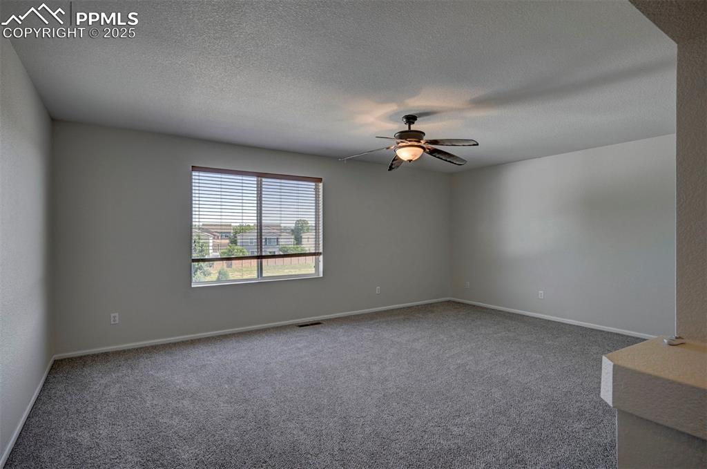 Image 33 of 50: Carpeted empty room with ceiling fan and a textured ceiling