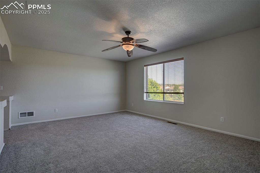 Image 34 of 50: Carpeted empty room with ceiling fan and a textured ceiling