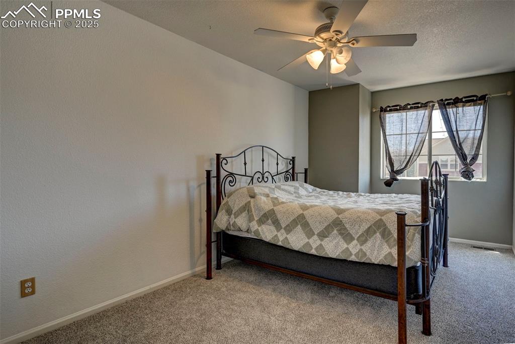 Image 39 of 50: Bedroom with carpet and ceiling fan