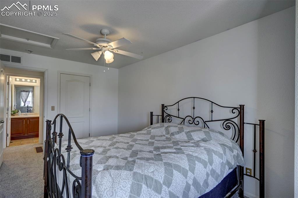 Image 40 of 50: Carpeted bedroom with ceiling fan and a sink