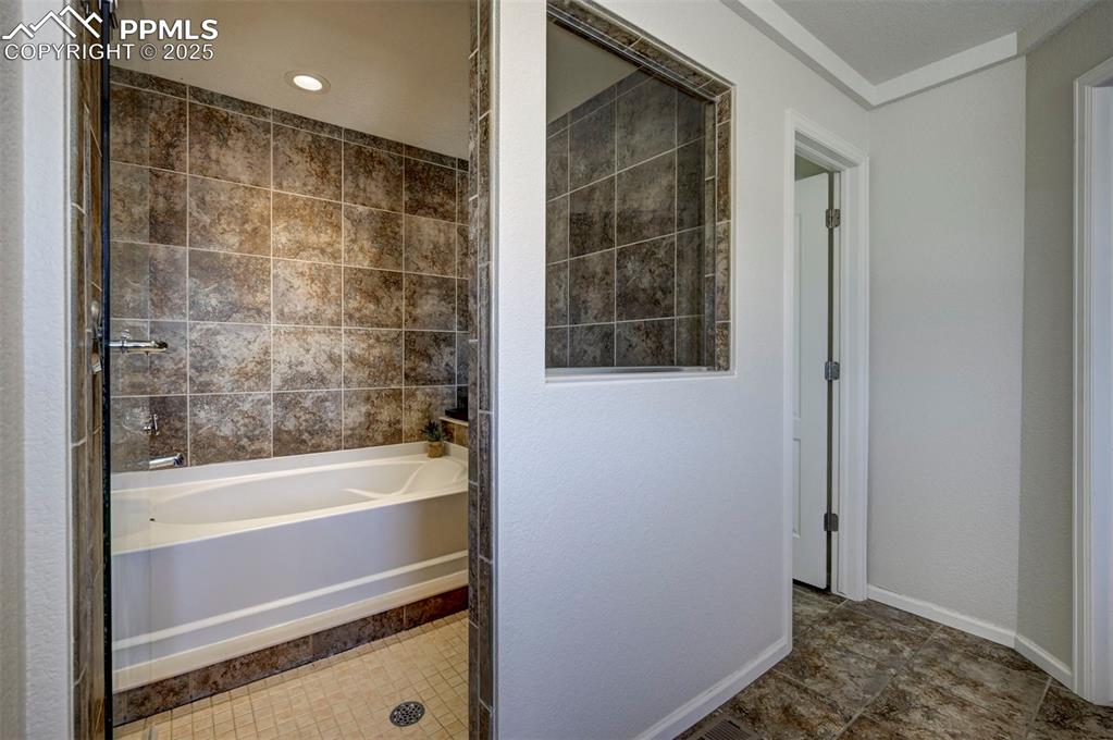 Image 47 of 50: Bathroom with tile patterned flooring, tub / shower combination, and crown